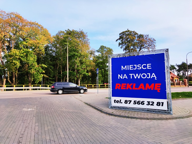 Kostka reklamowa przy ul. Wojska Polskiego, baner niebieskie tło z napisem Miejsce na Twoją reklamę